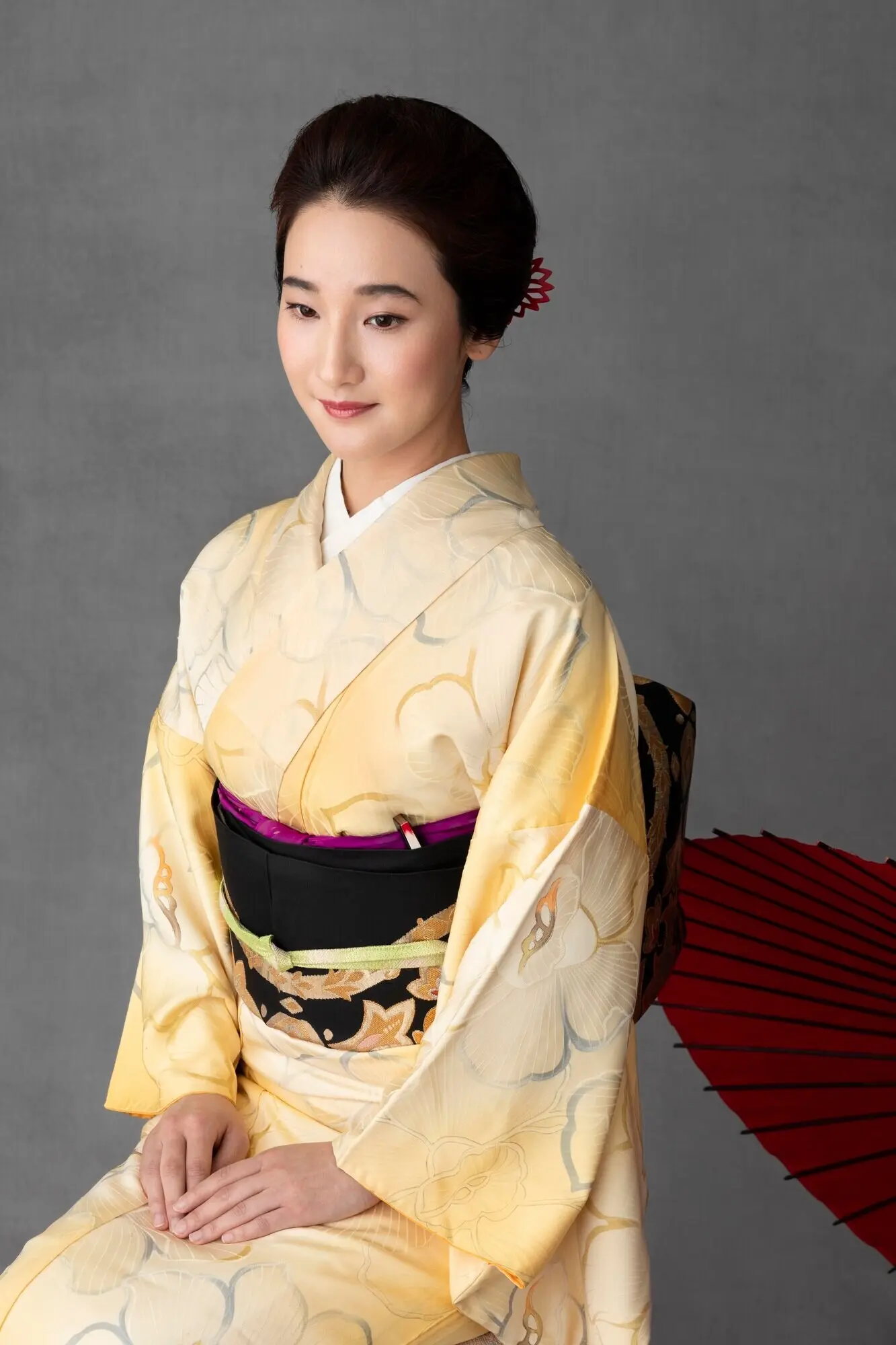 Attraktives japanisches Model mit einem roten Regenschirm